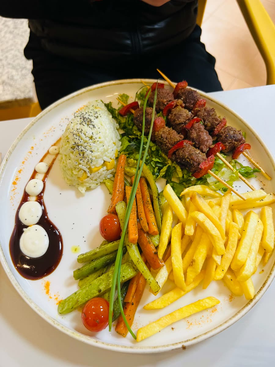 Moroccan beef brochette with rice, grilled vegetables and fries at a Mirleft restaurant