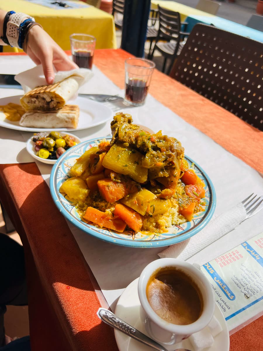 Traditional Moroccan couscous with chicken, carrots and vegetables in a painted ceramic bowl